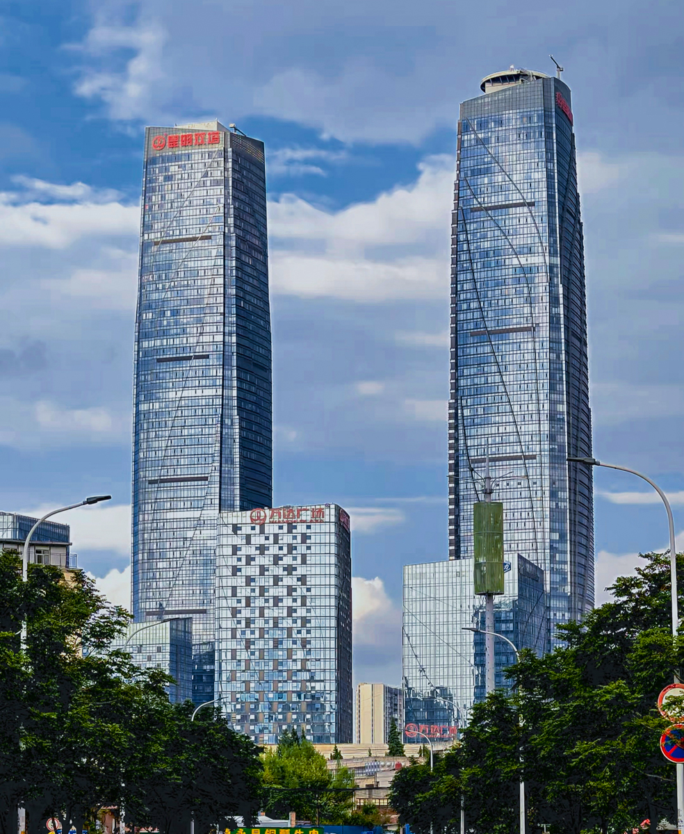 昆明城区与滇池航拍全景，高原春城的蓝天白云、远山轮廓与城市天际线
